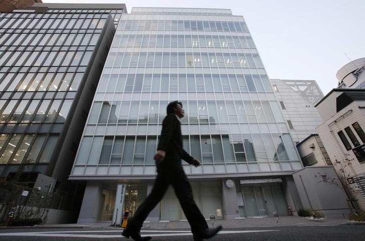 © Reuters. FILE PHOTO: A man walks past a building where Mt. Gox is housed in Tokyo