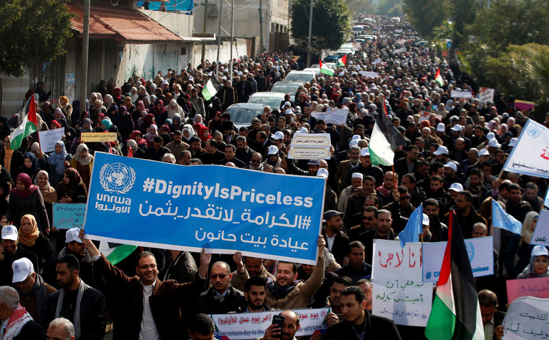 © Reuters. Palestinian employee of United Nations Relief and Works Agency (UNRWA) hold a sign during a protest against a U.S. decision to cut aid, in Gaza City