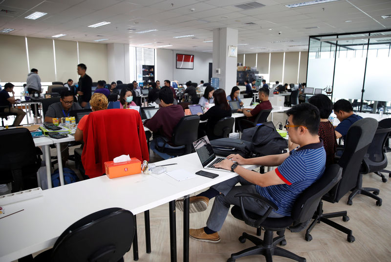 © Reuters. Employees work at Modalku's office in Jakarta, Indonesia