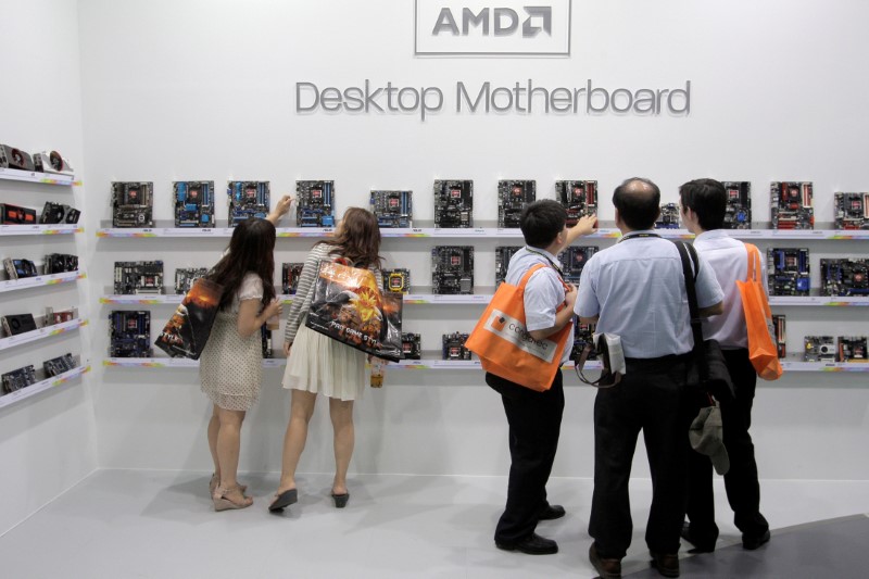 © Reuters. FILE PHOTO: Visitors look at motherboards being displayed at the AMD booth during the 2012 Computex exhibition at the TWTC Nangang exhibition hall in Taipei