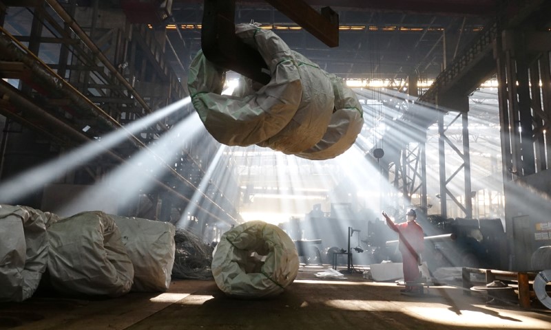 © Reuters. Worker directs a crane lifting steel wires at a factory of Dongbei Special Steel Group Co., Ltd. in Dalian