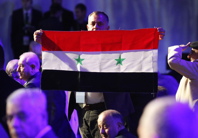 © Reuters. Un participante sostiene una bandera siria mientras asiste a una sesión del Congreso Sirio del Diálogo Nacional en el balneario del Mar Negro de Sochi, Rusia