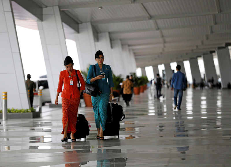 © Reuters. FILE PHOTO: Garuda Indonesia flight attendants arrive at Terminal 3 at Soekarno-Hatta Airport in Jakarta