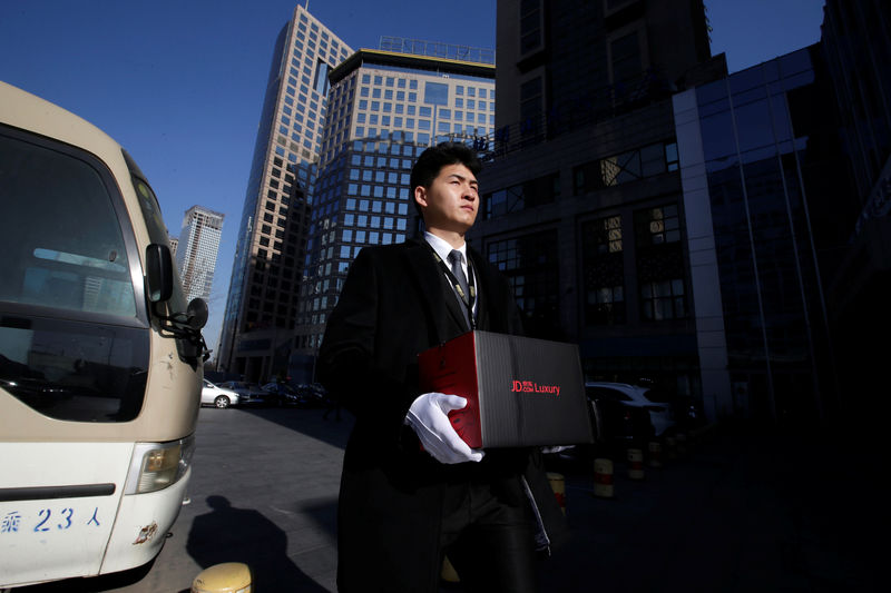 © Reuters. Member of JD's VIP delivery team Shang Kai delivers luxury goods to a customer in Beijing