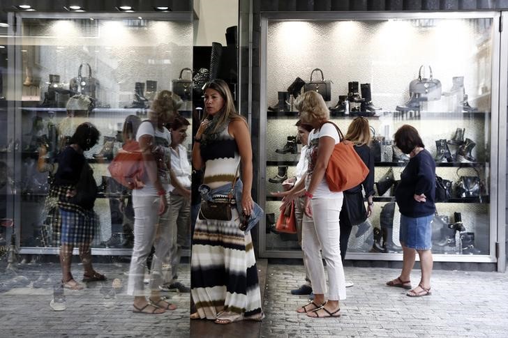 © Reuters. Women look at a shop window at a main shopping street in Athens