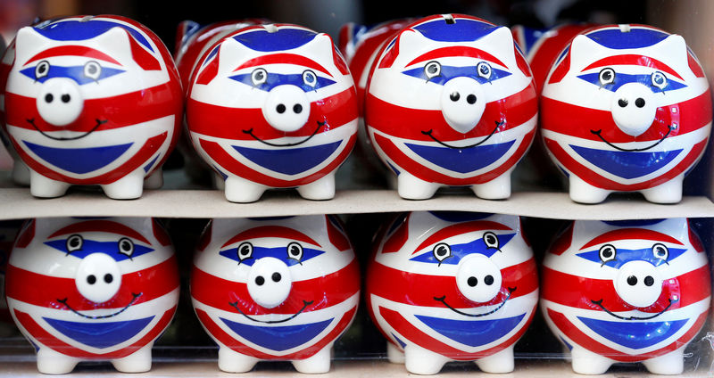 © Reuters. FILE PHOTO:Smiling Union Jack piggy banks are lined up for sale in the window of a souvenir store on Oxford Street in central London