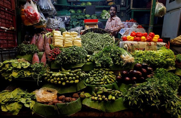 © Reuters. FILE PHOTO: A vegetables vendor waits for customers at a market in Kolkata