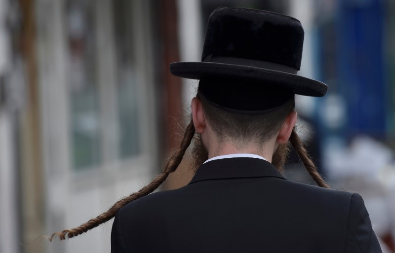 © Reuters. Imagen de archivo de un hombre judío ortodoxo caminando por una calle en Stamford Hill, al norte de Londres