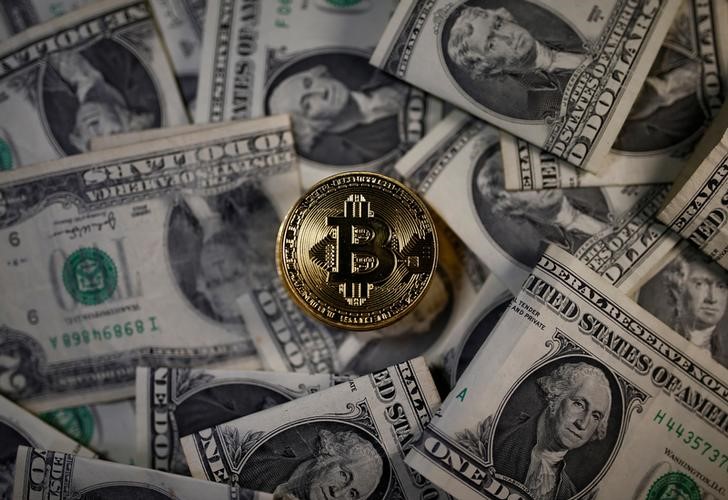 © Reuters. A bitcoin (virtual currency) coin placed on Dollar banknotes is seen in this illustration picture