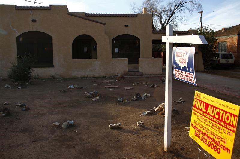© Reuters. A realtor and bank-owned sign is displayed near a house for sale in Phoenix