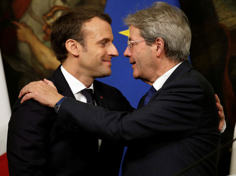 © Reuters. Il presidente del Consiglio, Paolo Gentiloni, e il presidente francese Emmanuel Macron si abbracciano durante una conferenza stampa a Palazzo Chigi