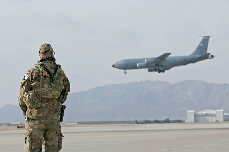 © Reuters. U.S. service member stands guard as an U.S. military transport plane lands at the Kandahar air base