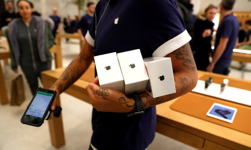 © Reuters. FILE PHOTO: An Apple Store staff shows Apple's new iPhones X after they go on sale at the Apple Store in Regents Street London