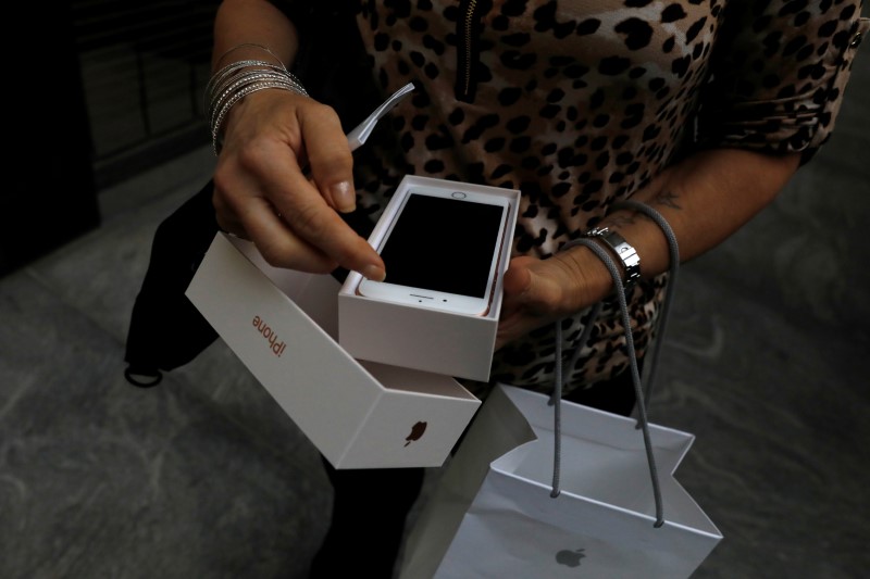 © Reuters. Imagen de archivo de una clienta abriendo la caja de su nuevo iPhone 8