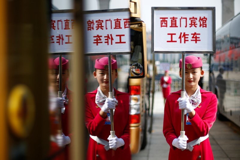 © Reuters. An usher holds a sign for a hotel for delegates returning from morning sessions on the second day of the 19th National Congress of the Communist Party of China the Great Hall of the People in Beijing