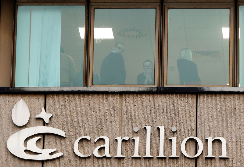 © Reuters. FILE PHOTO - Workers at Carillion look out of a window after the company went into liquidation, in Wolverhampton