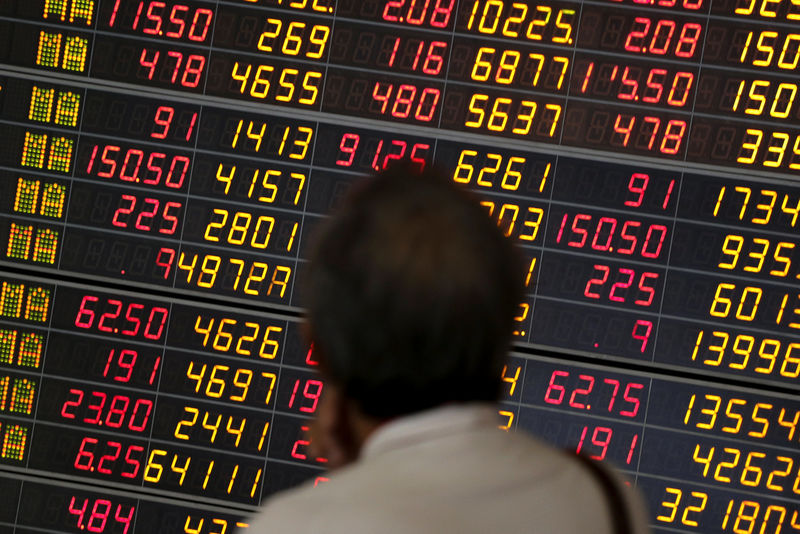 © Reuters. A man monitors a stock index board at a bank in Bangkok