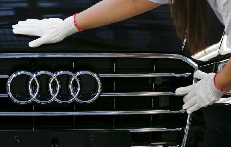 © Reuters. Worker fixes a car emblem as she assembles Audi A8 models at their plant in Neckarsulm near Heilbronn