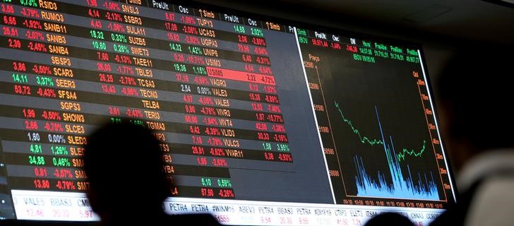 © Reuters. People look at an electronic board showing the graph of the recent fluctuations of market indices at the floor of Brazil's BM&F Bovespa Stock Market in downtown Sao Paulo