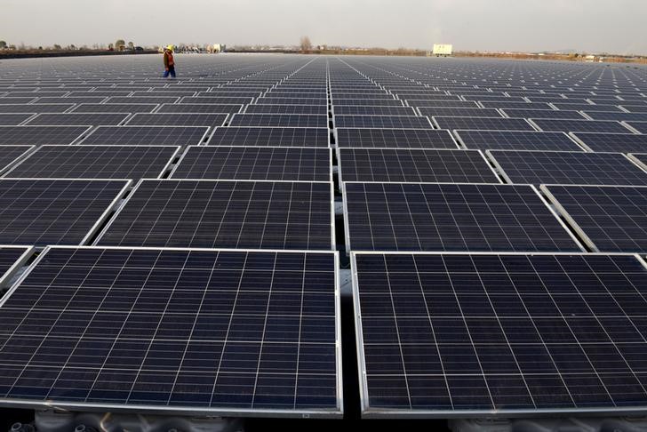 © Reuters. Worker walks among solar panels at a floating solar plant developed by China's Three Gorges Group, in Huainan