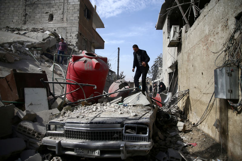 © Reuters. Pessoas observam destroços após ataque aéreo em Douma