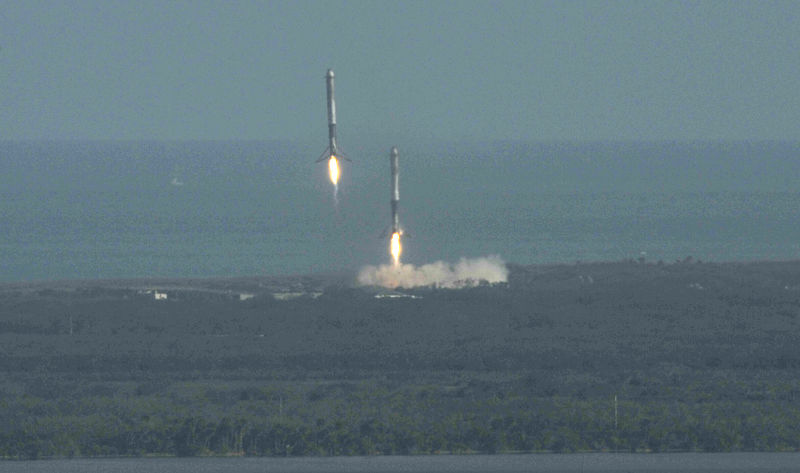 © Reuters. Propulsores que ayudaron en el lanzamiento del Falcon Heavy de SpaceX se preparan para aterrizar en el Centro Espacial Kennedy  en Cabo Cañaveral, Estados Unidos.