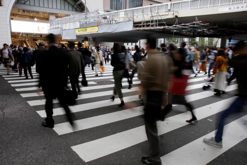 © Reuters. FILE PHOTO: Commuters cross a pedestrian crossing in Osaka