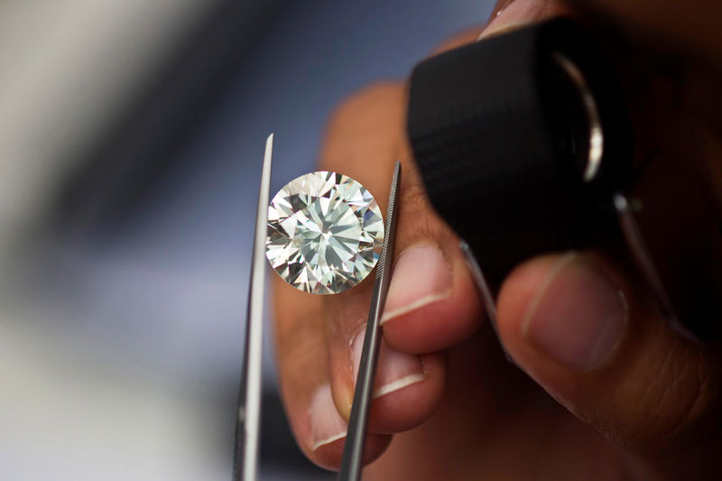 © Reuters. FILE PHOTO: A trader inspects a diamond during a four-day show at Israel's Diamond Exchange near Tel Aviv