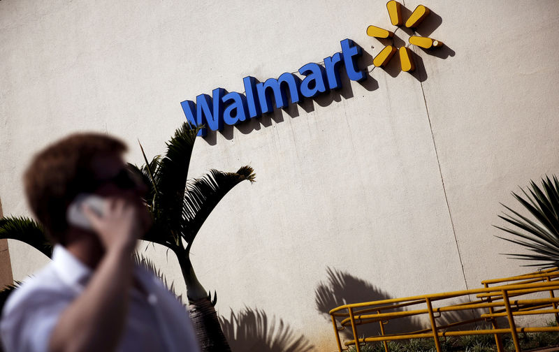 © Reuters. FILE PHOTO: A man talks on his mobile phone in front of a Wal-Mart store in Sao Paulo