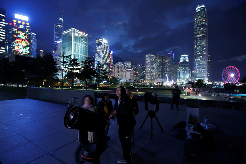© Reuters. People set up telescopes in front of the financial Central district for the super blue moon and eclipse in Hong Kong