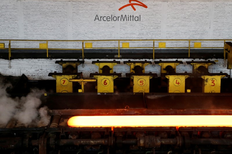 © Reuters. A red-hot steel plate passes through a press at the ArcelorMittal steel plant in Ghent