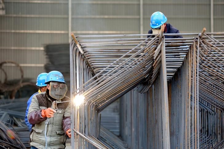 © Reuters. Workers wearing protective masks weld steel bars at a construction site in Huai'an
