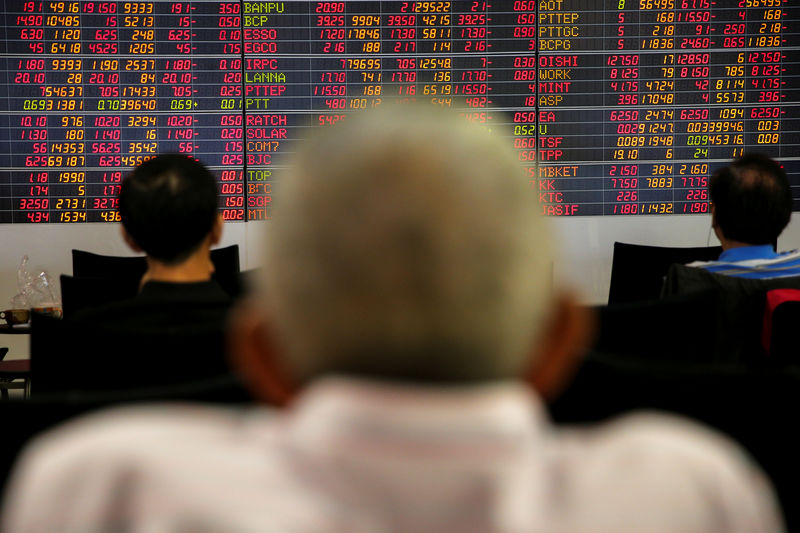 © Reuters. People monitor a stock index board at a bank in Bangkok
