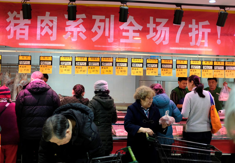 © Reuters. Customers buy pork at a supermarket in Beijing