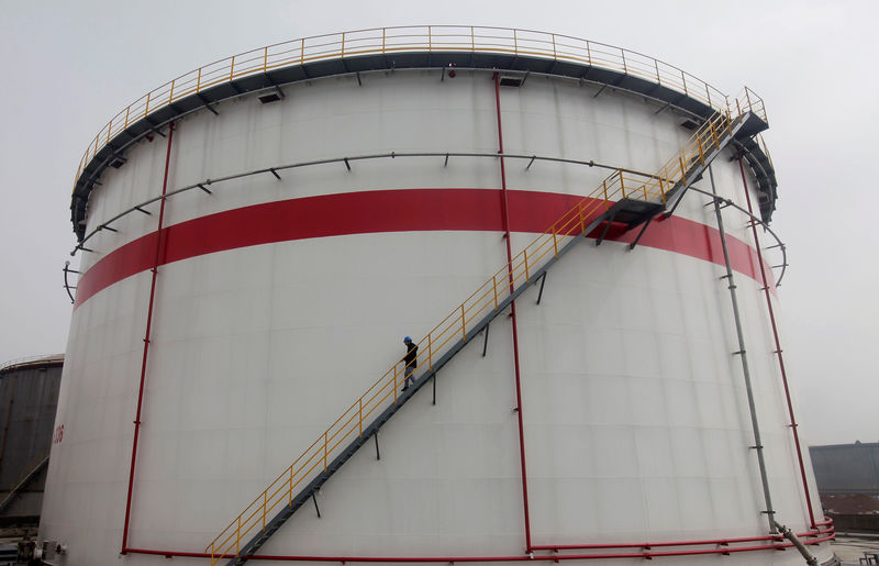 © Reuters. FILE PHOTO: A worker walks down stairs of an oil tank at a refinery in Wuhan