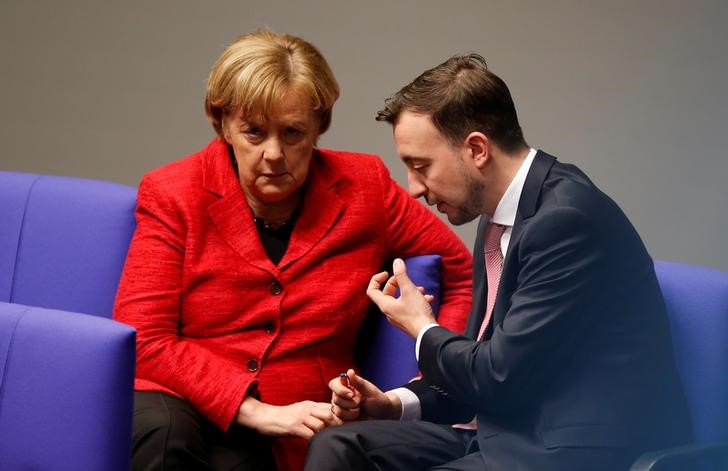 © Reuters. German Chancellor Angela Merkel talks to Paul Ziemiak of the Junge Union, the youth Organisation of the CDU/CSU during a session of the Bundestag, German lower house of Parliament in Berlin