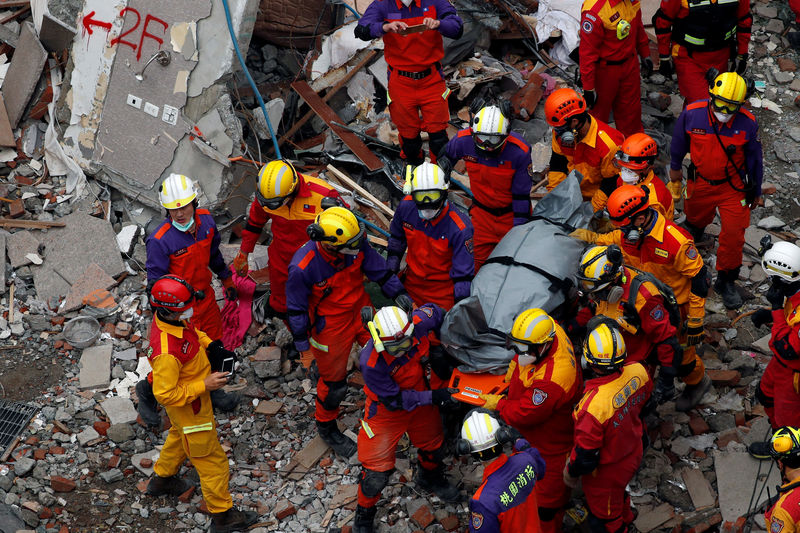 © Reuters. A body of a Hong Kong Canadian is carried out from a collapsed building after an earthquake hit Hualien