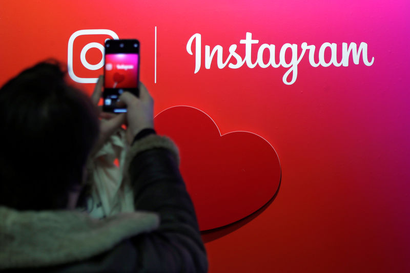 © Reuters. FILE PHOTO - A visitor takes a picture of the Instagram application logo at the Young Entrepreneurs fair in Paris