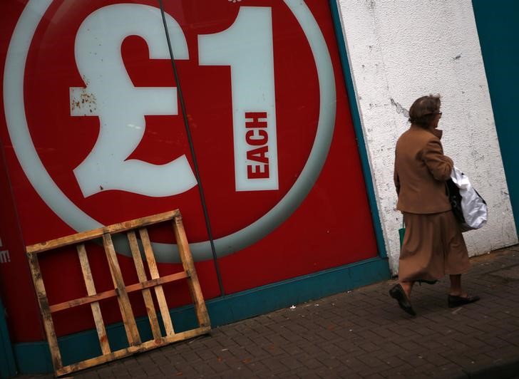 © Reuters. A woman walks past a discount shop in Leicester