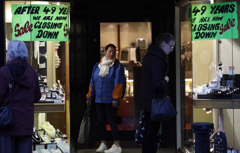 © Reuters. FILE PHOTO: Shoppers look at items for sale in a jewellers window display