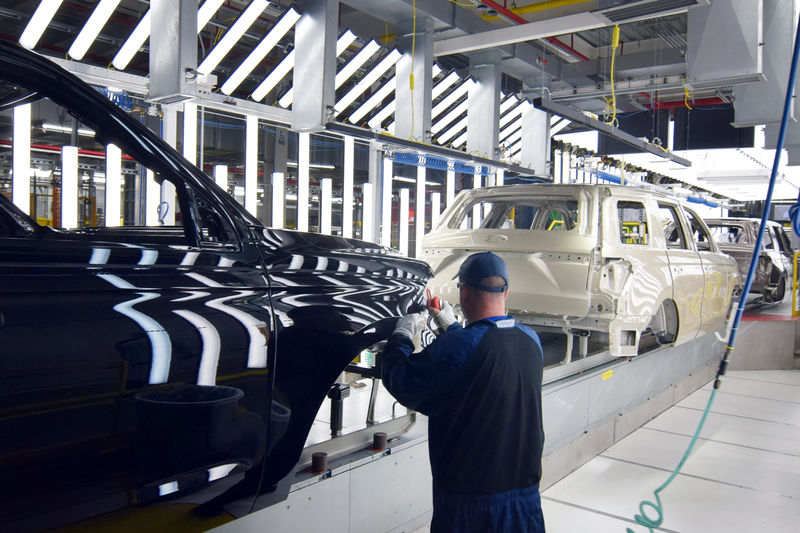 © Reuters. A Ford worker inspects paint work on the body of a Ford Expedition SUV at FordÕs Kentucky Truck Plant in Louisville