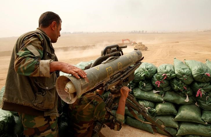 © Reuters. A Kurdish Peshmerga fighter with a Milan anti tank weapon guards against possible Islamic State suicide bomb attacks during a battle with Islamic State militants at Topzawa village, near Bashiqa, near Mosul, Iraq