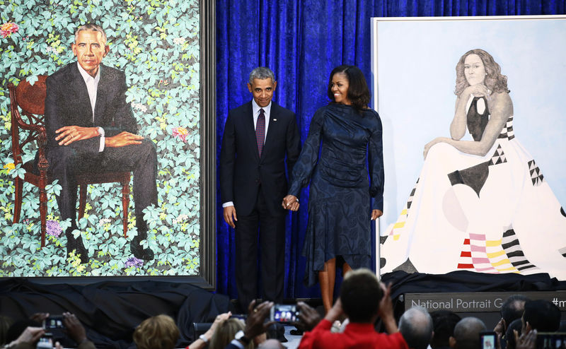 © Reuters. أوباما يمزح من أذنيه وشعره الرمادي مع إزاحة الستار عن لوحة زيتية له