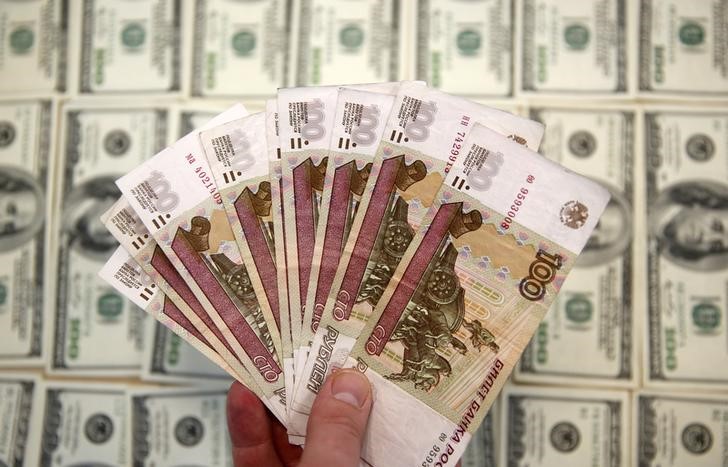 © Reuters. Банкноты по 100 рублей и $100