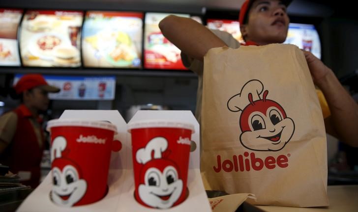 © Reuters. FILE PHOTO: A member of a Jollibee crew packs a take away food for a customer  inside a Jollibee franchise in BF Homes Paranaque, Metro Manila