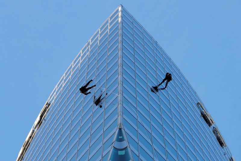 © Reuters. Workers climb the tower of France's state-owned electricity company EDF to check the structure in La Defense
