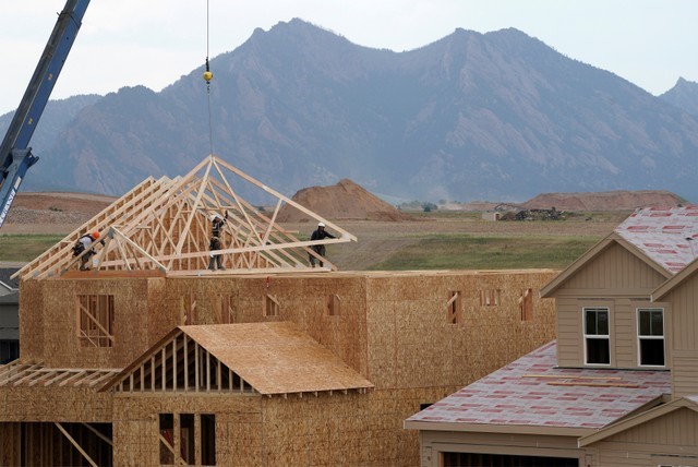 © Reuters. Workers install roof trusses onto a new house in Arvada