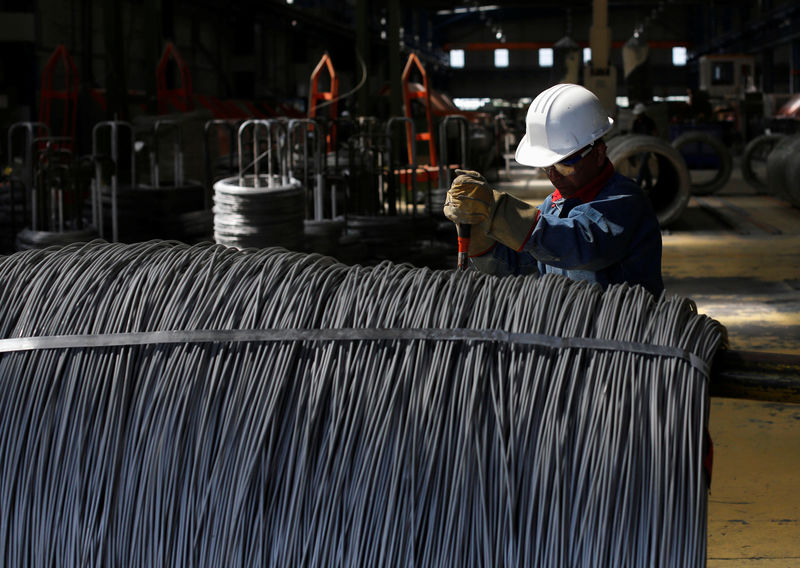 © Reuters. FILE PHOTO: Worker inspects wire rod at TIM stainless steel wire factory in Huamantla
