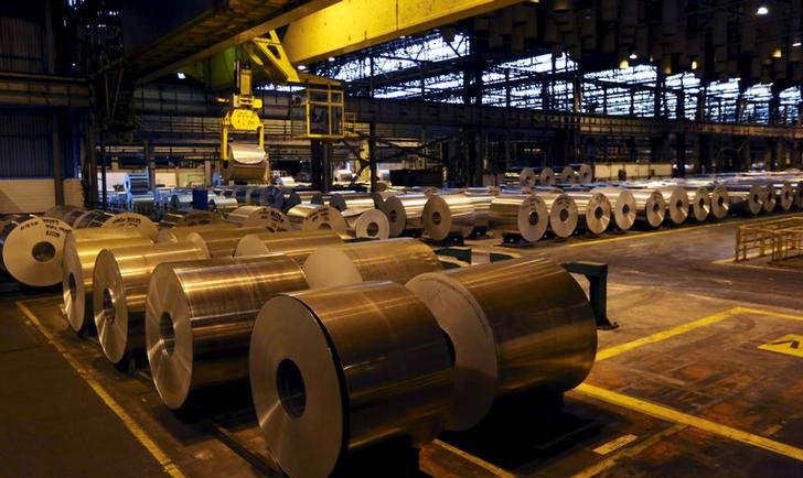 © Reuters. FILE PHOTO - A man walks past aluminum coil at an aluminum factory in Pindamonhangaba, Brazil