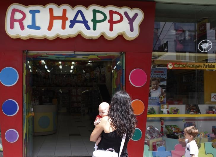 © Reuters. Uma mulher e seu bebê na frente de uma loja da Ri Happy, em São Paulo, Brasil